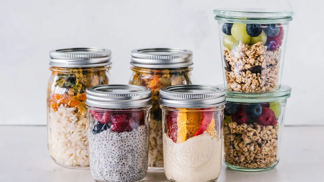 Two meal-prep containers of rice, chicken and vegetables on a kitchen counter
